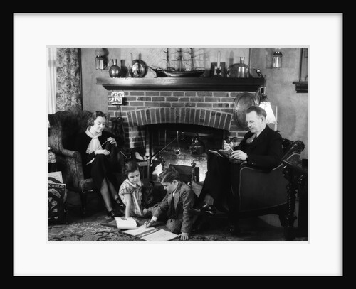 1930s family of four sitting in front fireplace mother knitting father reading smoking pipe kids doing homework by Anonymous