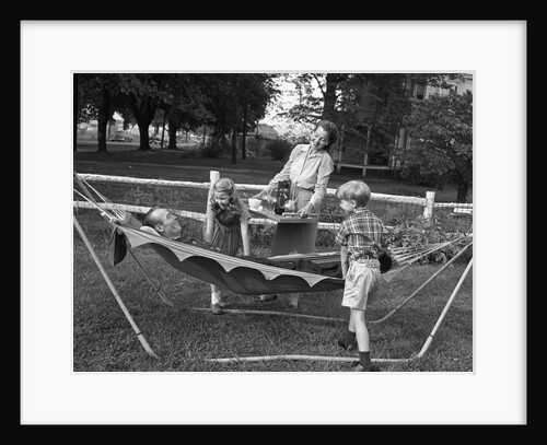 1950s mom & kids serving dad in hammock by Anonymous