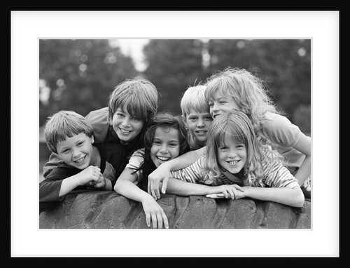 1970s 1980s group of six boys & girls gathered together on large playground tire by Anonymous