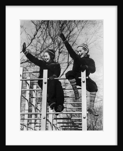 1930s two children waving while sitting on playground equipment by Anonymous