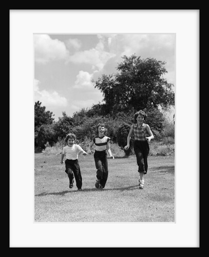 1950s three girls running in grassy field by Anonymous