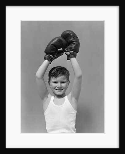 1940s boy child winner wearing boxing gloves holding hands above head looking at camera by Anonymous