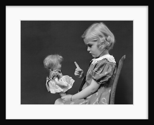 1930s little blond girl scolding her doll pointing finger by Anonymous