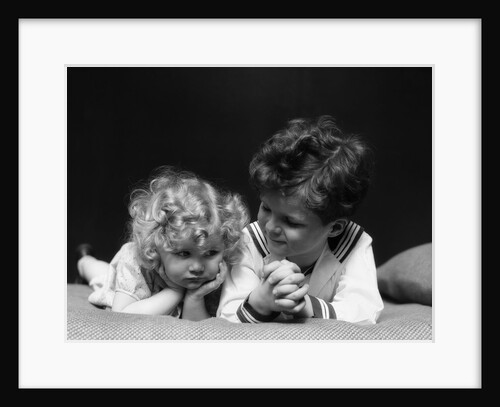 1930s two children brother and sister lying on couch by Anonymous