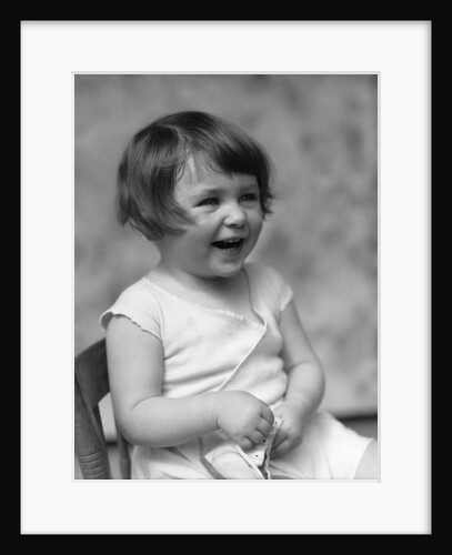 1930s smiling laughing toddler girl holding shoe by Anonymous
