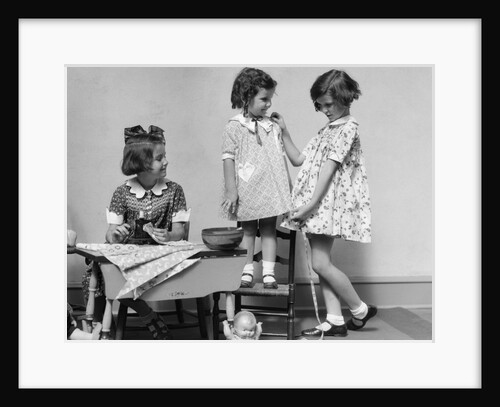 1930s three girls playing fashion seamstress pretending measuring fabric by Corbis