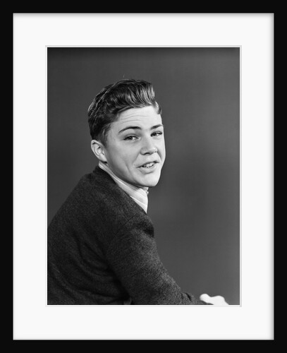 1950s portrait of smiling teenage boy looking over shoulder by Anonymous