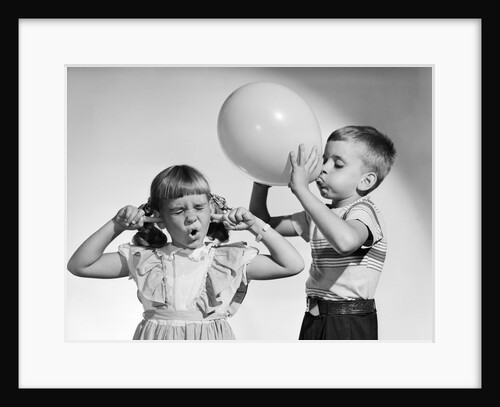 1950s little boy blowing up big balloon little girl with fingers in ears eyes closed by Anonymous