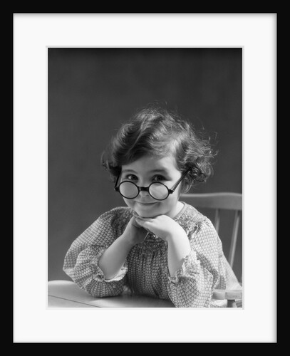 1930s portrait little girl smiling wearing big round eyeglasses looking at camera by Anonymous