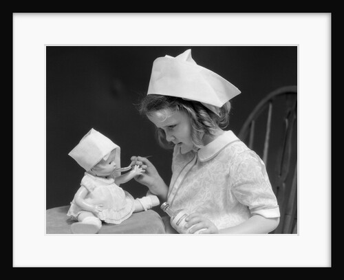 1930s little girl playing nurse with doll spoonful of medicine by Anonymous