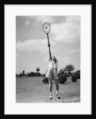 1930s girl playing tennis jumping to hit ball overhead by Anonymous