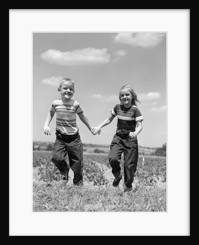 1950s boy girl running grassy farm field holding hands by Anonymous