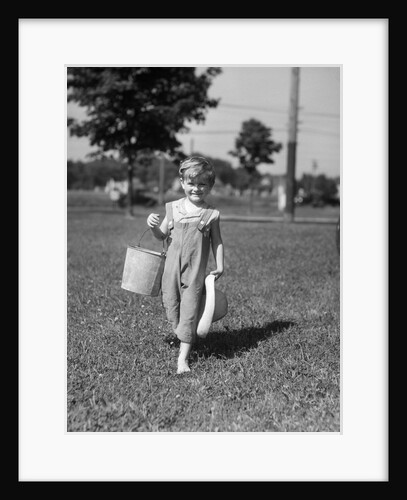 1930s child boy with bucket straw hat walking grass by Anonymous