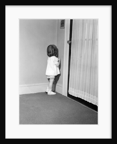 1950s 1960s little girl in white dress being punished standing in a corner by Anonymous