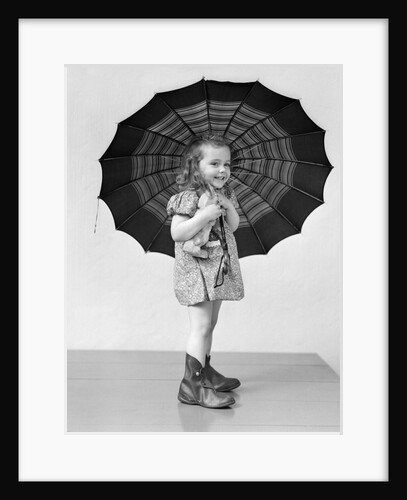 1930s 1940s child smiling little girl holding rainy day umbrella by Anonymous