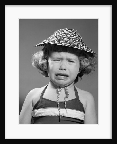 1960s portrait of girl wearing straw hat and crying by Anonymous