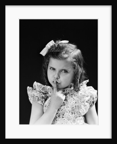 1950s child serious little girl pressing finger to lips hush be quiet secret by Anonymous