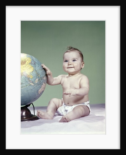 1960s smiling baby girl sitting in diapers hand touching world globe by Anonymous
