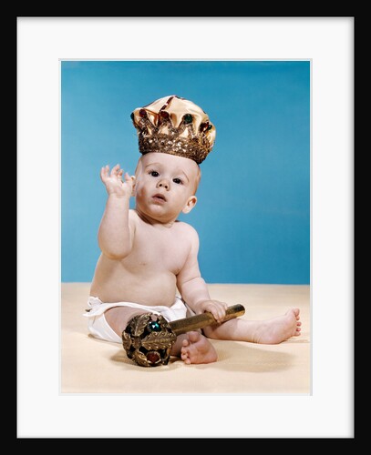 1960s baby wearing cloth diaper and crown holding a scepter waving with one arm raised looking at camera by Anonymous