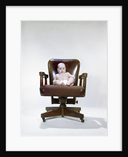 1960s chubby baby in diaper sitting in office executive chair by Anonymous