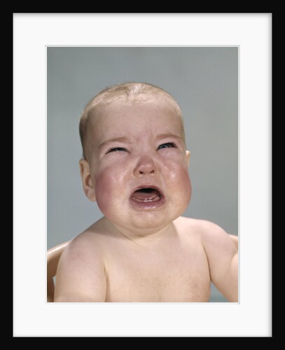 1960s portrait of very unhappy crying baby with red chubby cheeks by Anonymous