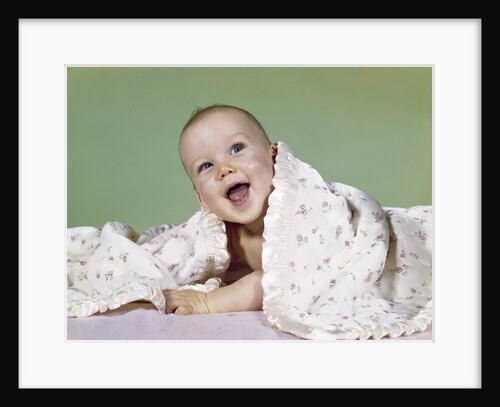 1960s smiling happy baby peeking out from under a blanket by Anonymous