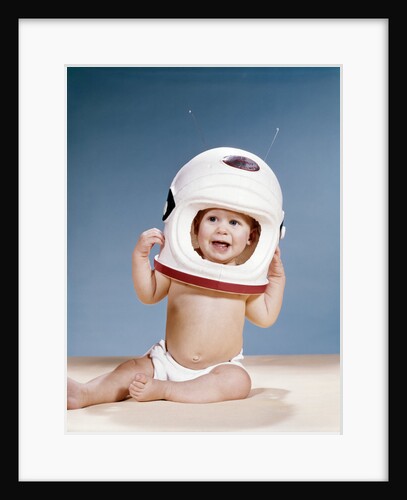 1960s baby wearing styrofoam astronaut helmet by Anonymous