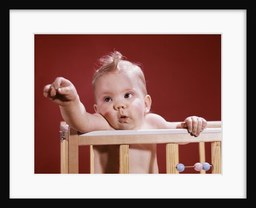 1960s baby reaching out from crib by Anonymous