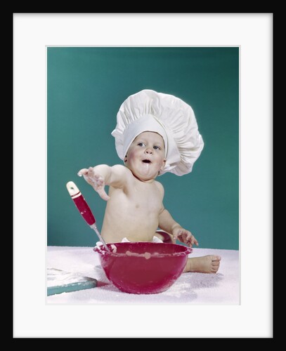 1960s baby wearing chef hat with red mixing bowl and spoon funny facial expression by Anonymous