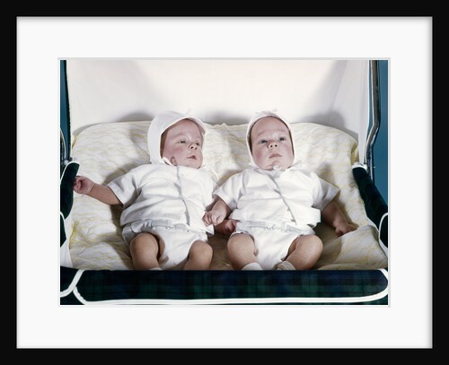 1950s 1960s twin boys dressed in white lying in stroller side by side by Anonymous