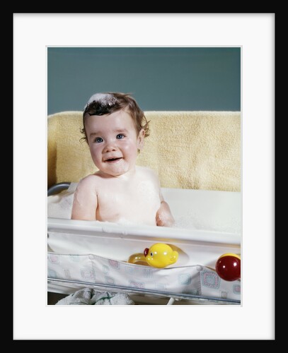 1960s smiling baby in bath looking at camera by Anonymous