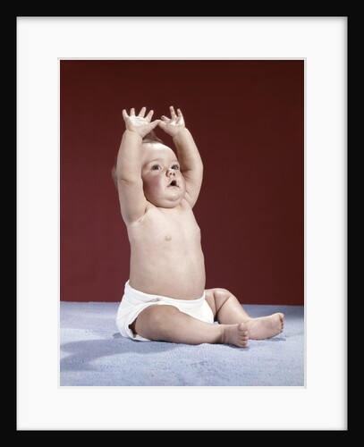 1960s baby wearing cloth diaper sitting arms raised over head by Anonymous