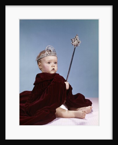 1960s baby girl wearing rhinestone tiara and red velvet cloak holding scepter by Anonymous