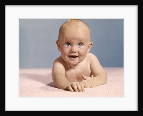 1970s smiling happy baby crawling straight ahead on pink blanket looking at camera by Anonymous