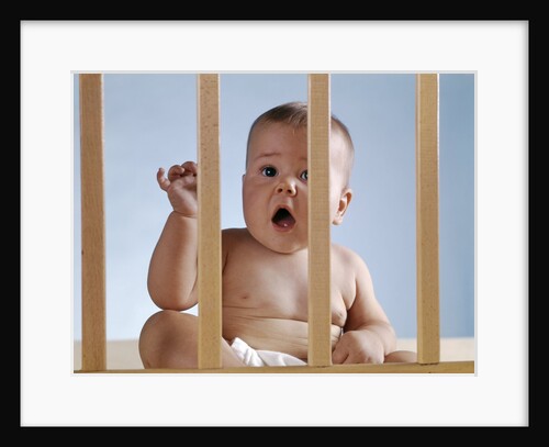 1960s baby in crib or playpen looking through bars alarmed expression by Anonymous