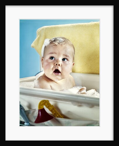 1960s baby in bath looking up by Anonymous