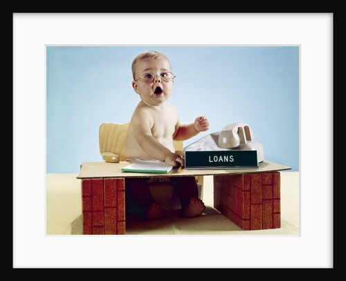 1960s baby businessman sitting at toy desk loans sign wearing eyeglasses looking at camera by Anonymous