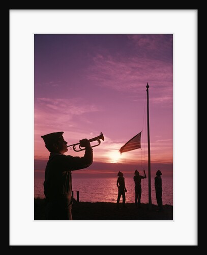 1960s boy scout blowing bugle as others raise american flag at camp sunset ceremony by Anonymous