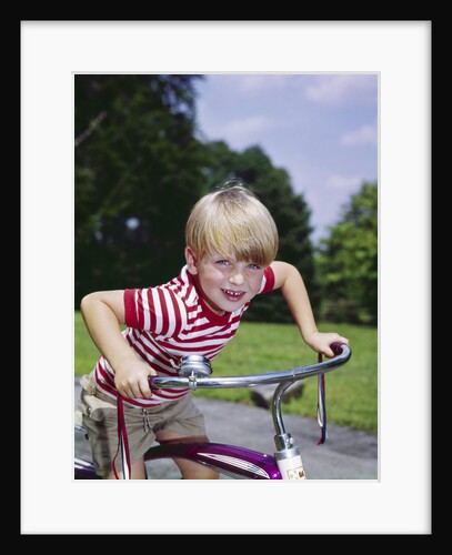 1970s 1960s smiling blond boy leaning over handlebars of bicycle looking at camera by Anonymous