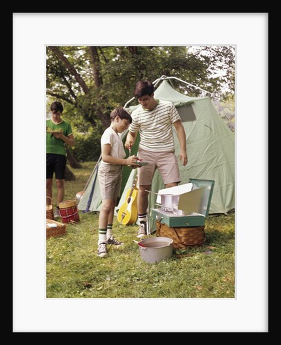 1960s three boys at campsite cooking camp stove eating food tent teens by Anonymous