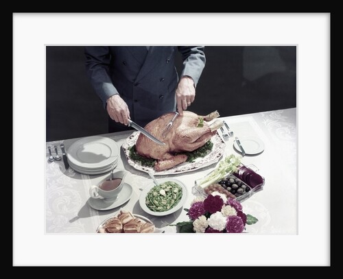 1950s male hands about to carve thanksgiving turkey table setting plates gravy rolls olives crudities by Anonymous