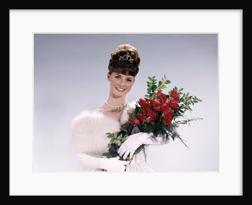 1960s woman prom queen wearing white evening dress holding bouquet of flowers red roses looking at camera by Anonymous