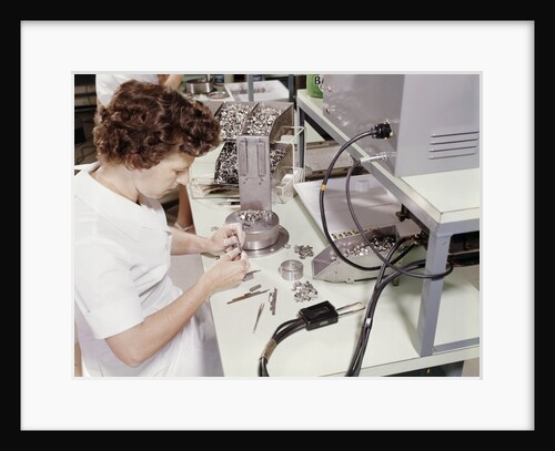 1960s woman electronics factory worker assembling television color gun for television picture tube by Anonymous