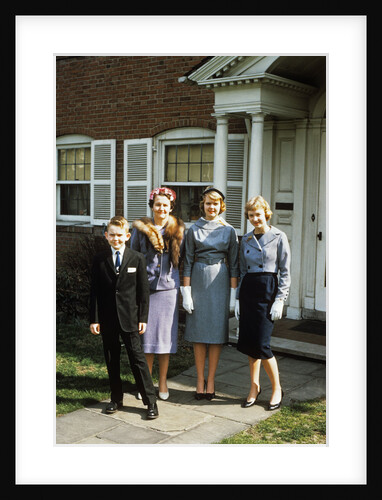 1950s mother with teenage girls & younger son dressed up posing in front of house by Anonymous