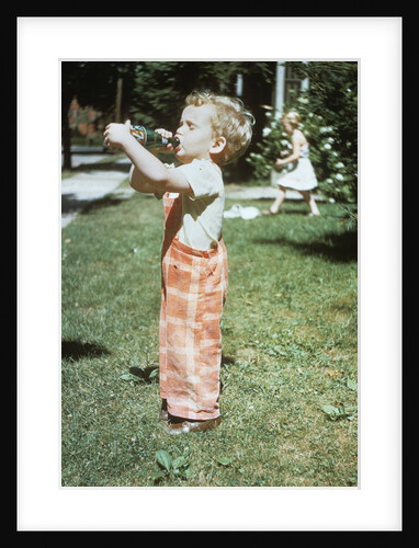 1950s little boy outside drinking soda from a 7up bottle 1951 by Anonymous