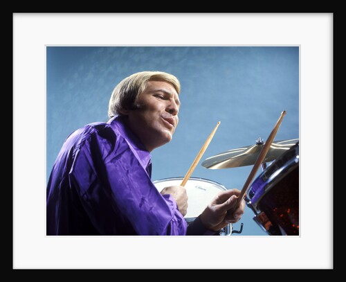1970s musician blond man playing drums wearing purple shirt by Anonymous