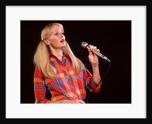 1970s blond woman ponytails long hair microphone plaid shirt singing folk music by Anonymous