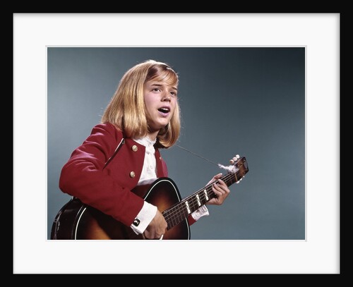1960s blond teenaged girl singing and playing acoustic guitar by Anonymous