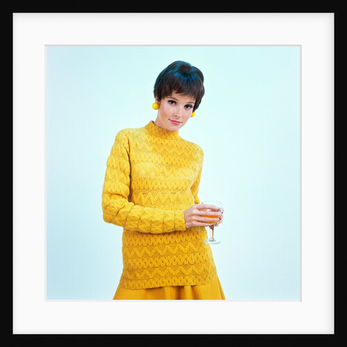 1960s brunette woman short pixie hair style yellow knit sweater earrings holding wine glass by Anonymous