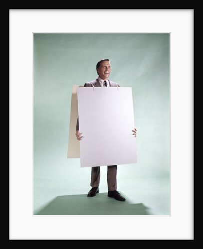 1960s smiling man wearing blank sandwich board by Anonymous